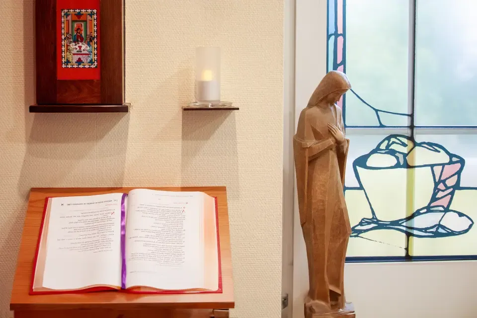 A wooden sculpture and a bible in a praying room